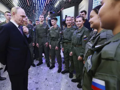 Russian President Vladimir Putin, left, speaks with cadets of the Military-Sports Training and Patriotic Education Center after visiting the interactive exhibition dedicated to the 155th Separate Guards Orders of Suvorov and Zhukov Kursk Marine Brigade named after Hero of Russia Mikhail Gudkov, at the branch of the National Center "Russia" in Vladivostok, Russia, on Thursday, Sept. 4, 2025. (Vladimir Smirnov, Sputnik, Kremlin Pool Photo via AP)