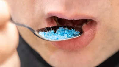 Microplastic in food, Environment and health concept, Person putting a spoon with plastic particles in his mouth