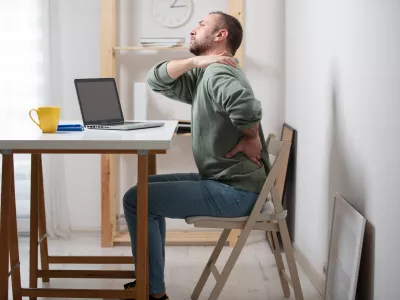 Man with neck pain while working on a laptop. / Foto: M-gucci