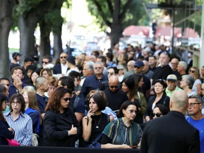 People queue outside the Armani/Teatro to pay tribute as designer Giorgio Armani lies in state, following his death at the age of 91, in Milan, Italy September 6, 2025. REUTERS/Claudia Greco