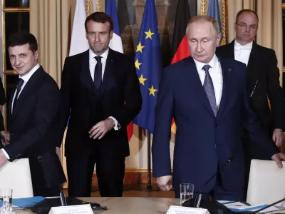 Russian President Vladimir Putin, right, Ukrainian President Volodymyr Zelenskiy, left, and French President Emmanuel Macron, center, arrive at a working session at the Elysee Palace Monday, Dec. 9, 2019 in Paris. Russian President Vladimir Putin and Ukraine's president are meeting for the first time at a summit in Paris to find a way to end the five years of fighting in eastern Ukraine. (Ian Langsdon/Pool via AP)