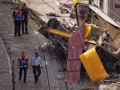 Police officers inspect the site where a tourist streetcar derailed and crashed in Lisbon, Portugal, Thursday, Sept. 4, 2025. (AP Photo/Armando Franca)