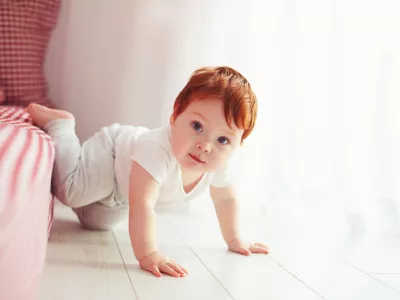 cute toddler baby getting off the bed, crawling at home / Foto: Olesiabilkei