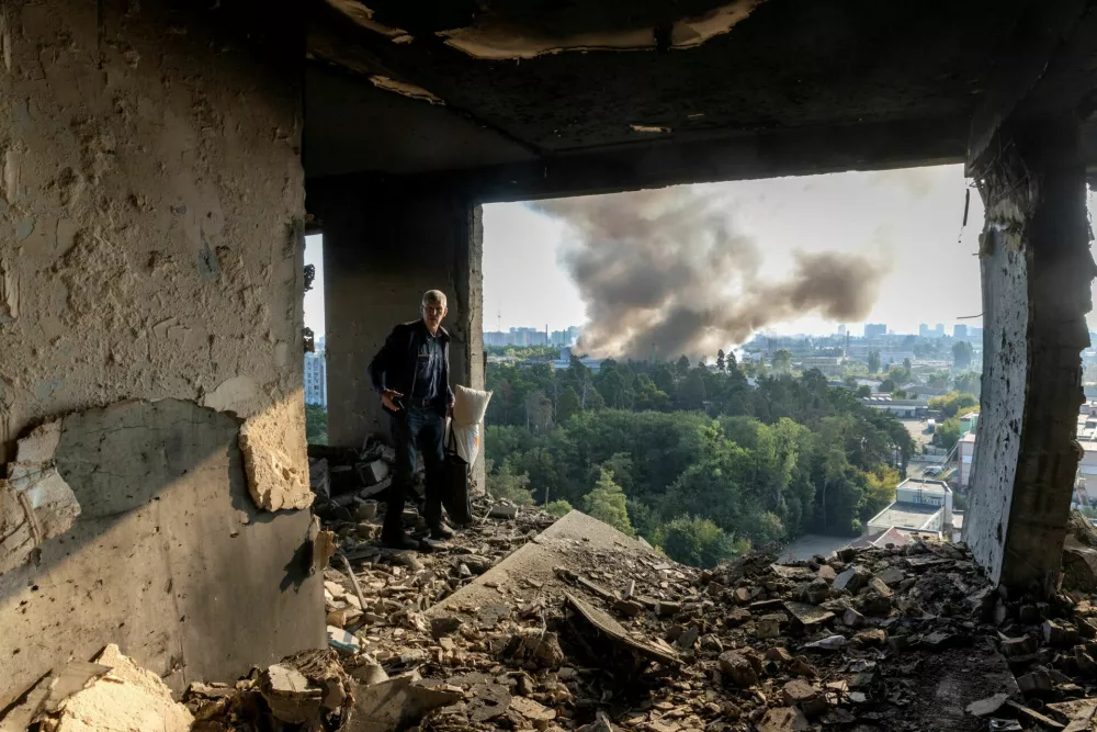 A friend of the owner inspects the damage in an apartment that was hit during a Russian drone strike, amid Russia's attack on Ukraine, in Kyiv, Ukraine September 7, 2025. REUTERS/Thomas Peter    TPX IMAGES OF THE DAY