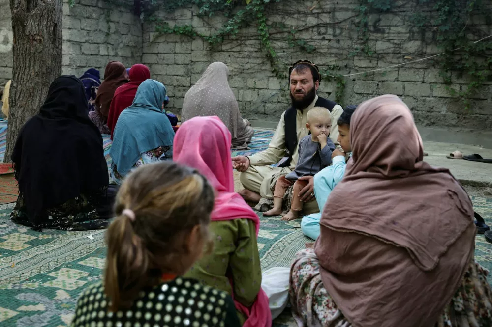 Jabbar Khan, 43, sits with his family outside his damaged home, following a deadly earthquake in Bambakot village in Dera Noor district in Nangarhar province, Afghanistan September 6, 2025. REUTERS/Sayed Hassib