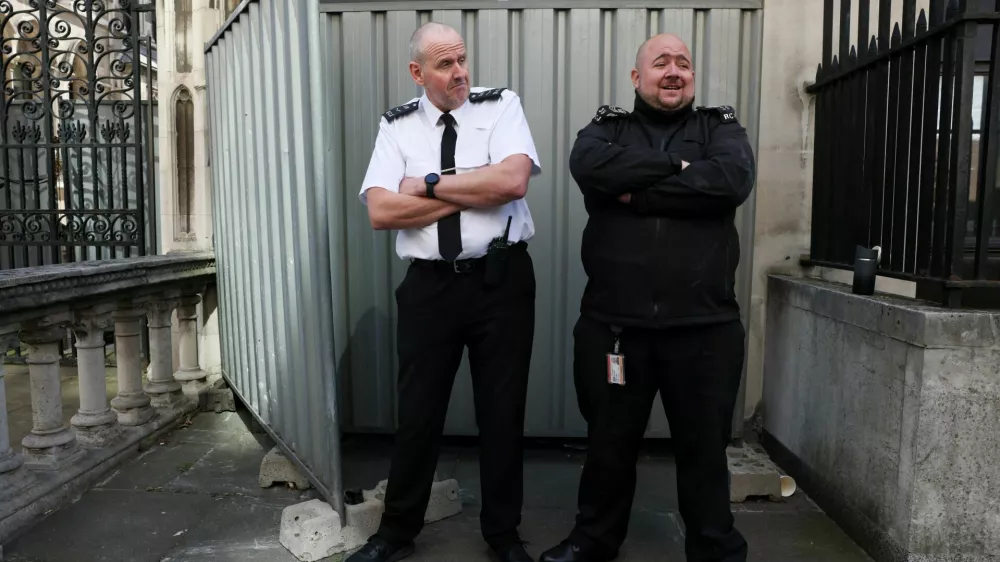 Security guards stand in front a screen covering a new mural by anonymous artist Banksy on the Royal Courts of Justice in London, Britain, September 8, 2025. REUTERS/Jack Taylor   TPX IMAGES OF THE DAY