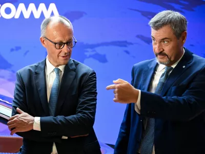 Bavarian State Premier Markus Soeder gestures next to German Chancellor Friedrich Merz as they tour the IAA Mobility 2025 auto show in Munich, Germany, September 9, 2025. REUTERS/Angelika Warmuth