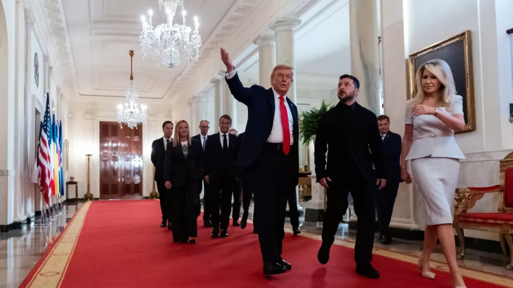 President Donald Trump, center, walks in the Cross Hall with Ukrainian President Volodymyr Zelenskyy, followed by British Prime Minister Keir Starmer, French President Emmanuel Macron, German Chancellor Friedrich Merz, Italian Prime Minister Giorgia Meloni, Finnish President Alexander Stubb, NATO Secretary General Mark Rutte and European Commission President Ursula von der Leyen, at the White House, Monday, Aug. 18, 2025, in Washington. (AP Photo/Alex Brandon)