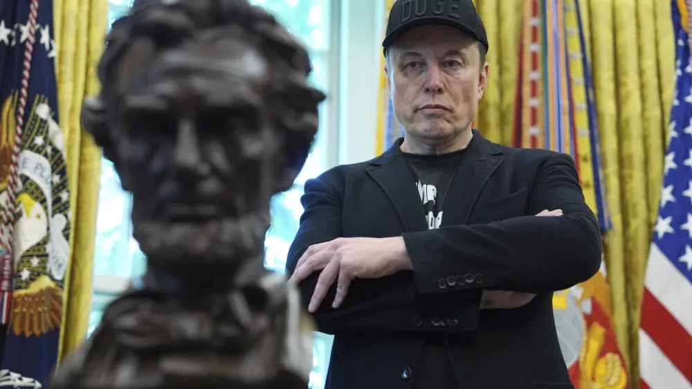 FILE - Elon Musk listens as President Donald Trump speaks during a news conference in the Oval Office of the White House, May 30, 2025, in Washington. (AP Photo/Evan Vucci, File)