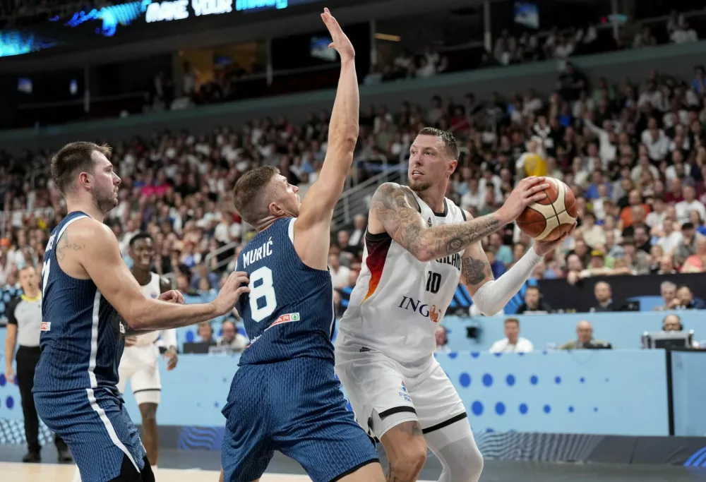 Basketball - FIBA EuroBasket 2025 - Quarter Finals - Germany v Slovenia - Xiaomi Arena, Riga, Latvia - September 10, 2025 Germany's Daniel Theis in action with Slovenia's Luka Doncic and Edo Muric REUTERS/Ints Kalnins