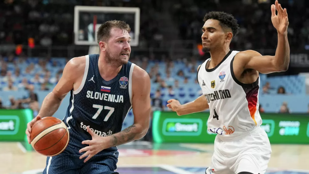 Basketball - FIBA EuroBasket 2025 - Quarter Finals - Germany v Slovenia - Xiaomi Arena, Riga, Latvia - September 10, 2025 Slovenia's Luka Doncic in action with Germany's Maodo Lo REUTERS/Ints Kalnins