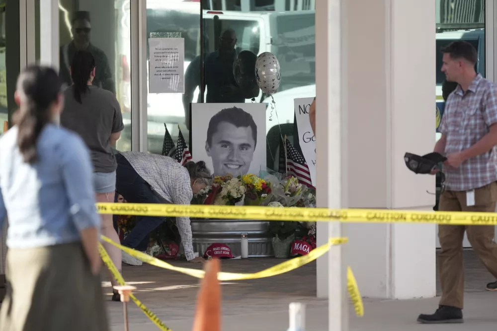 Well-wishers pay their respects at a makeshift memorial at the national headquarters of Turning Point USA after the shooting death of Charlie Kirk, CEO of the organization, during a Utah college event Wednesday, Sept. 10, 2025, in Phoenix. (AP Photo/Ross D. Franklin)