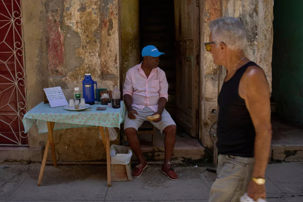 A coffee and tobacco vendor sits outside his home during a blackout in Havana, Wednesday, Sept. 10, 2025. (AP Photo/Ramon Espinosa)