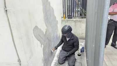 A worker removes the new artwork by Banksy, which shows a judge attacking a protester with a gavel, after it appeared at the Royal Courts of Justice in London on Monday, on Wednesday, Sept. 10, 2025. (Danny Halpin/PA via AP)