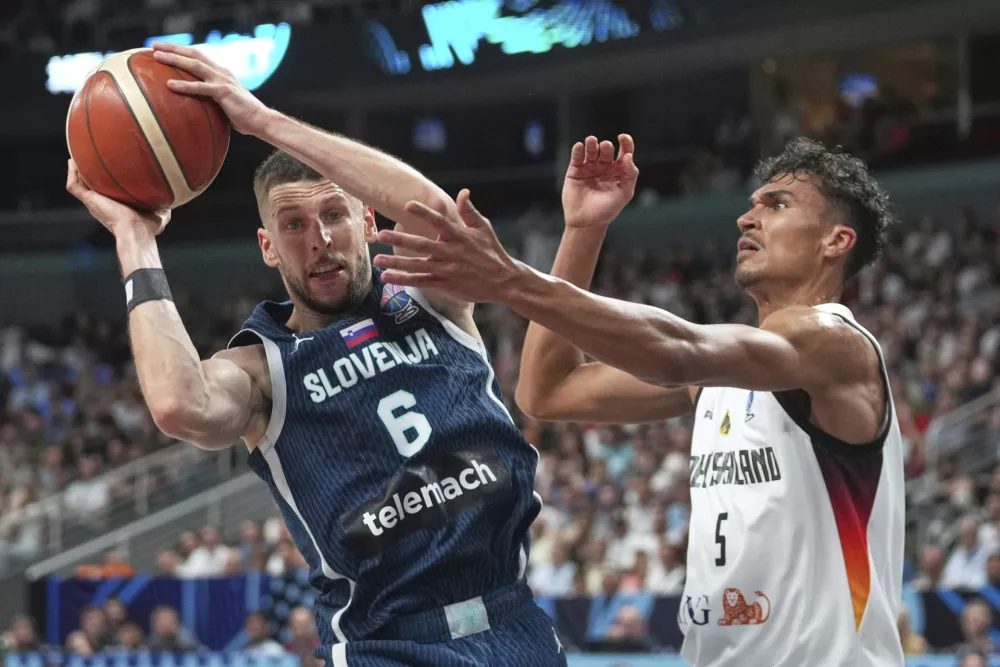 Slovenia's Aleksej Nikolic, left, challenges for the ball with Germany's Tristan Da Silva during the Eurobasket, European Basketball Championship quarter final match between Germany and Slovenia at the Riga Arena in Riga, Latvia, Wednesday, Sept. 10, 2025. (AP Photo/Sergei Grits)