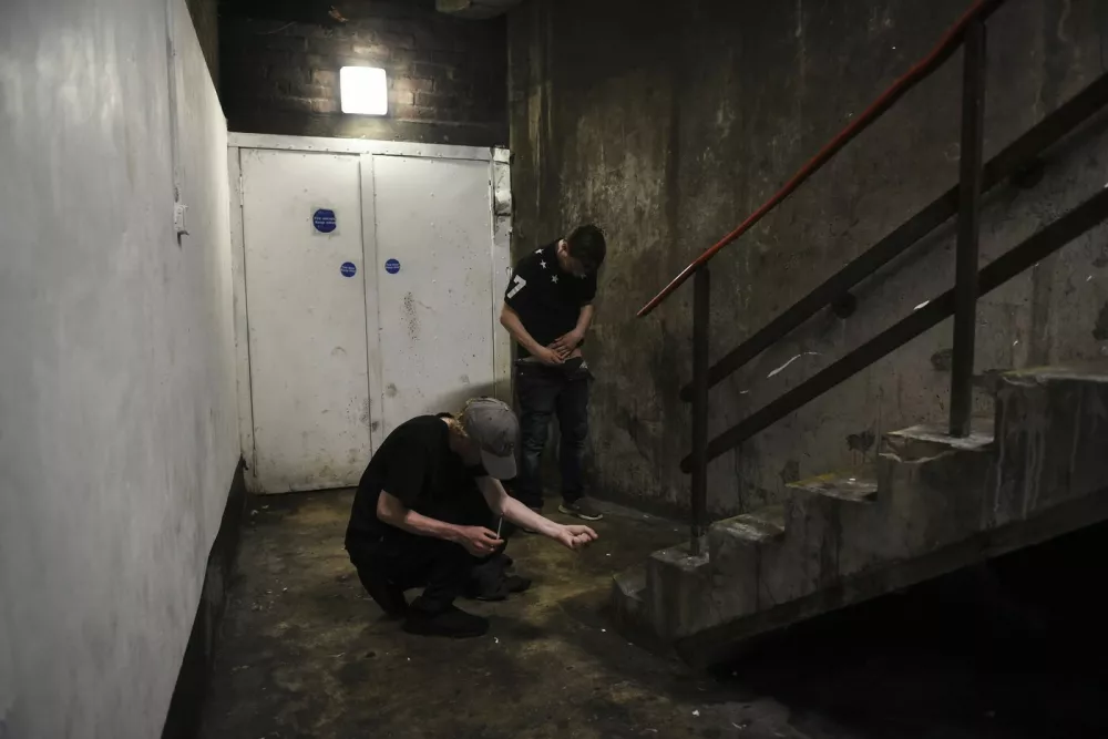 James Muir, left, and Tony Nugent use heroin in a stairwell popular with addicts in Glasgow, Scotland, July 27, 2019. The opioid addicts of Scotland's "Trainspotting" generation are hitting middle age, and drug-related deaths are on the rise.,Image: 462977767, License: Rights-managed, Restrictions:, Model Release: no