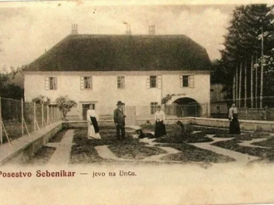 Na razglednici, ki bi jo lahko izdala in založila Matilda in Lovro Sebenikar so &scaron;tiri osebe; v klobuku bi lahko bil Lovro Sebenikar, desno od njega v gosposki obleki Matilda Sebenikar, na skrajni desni Franja Maister in na skrajni levi Jožefa Tom&scaron;ič. Vir: &Scaron;krabec, M. 1990. Dežela ob Cerkni&scaron;kem jezeru. / Foto: Nn