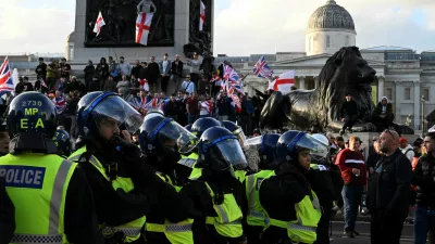 Police officers stand guard next to supporters of British anti-immigration activist Stephen Yaxley-Lennon, also known as Tommy Robinson, during a rally, in London, Britain, September 13, 2025. REUTERS/Chris J. Ratcliffe
