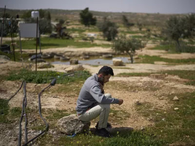 FILE - Basel Adra, one of the directors of the Oscar winner documentary "No Other Land", speaks on the phone as he sits in an area near the house of Palestinian co-director Hamdan Ballal, in Susiya in Masafer Yatta, south Hebron hills, March 25, 2025. (AP Photo/Leo Correa, File)