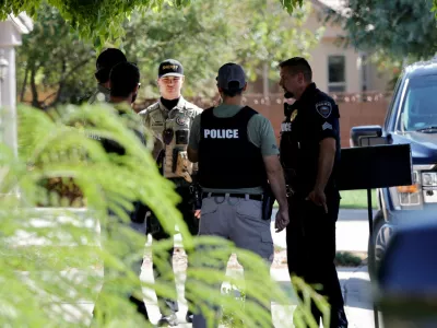A Washington County sheriff's deputy joins Washington City police officers outside a residence in Washington, Utah, associated with Tyler Robinson, the suspect in the fatal shooting of U.S. conservative commentator Charlie Kirk during an event at Utah Valley University, U.S., September 12, 2025. REUTERS/Steve Marcus