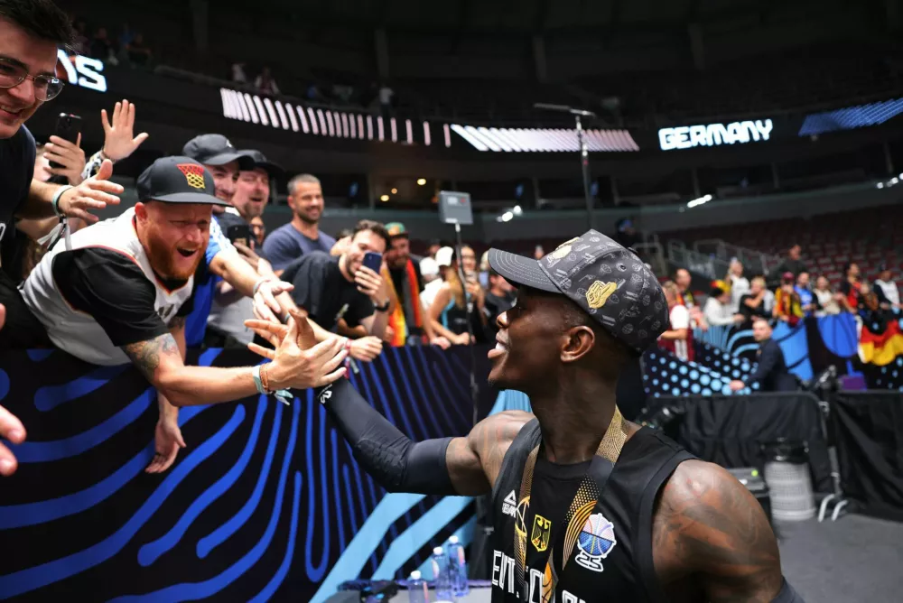Basketball - FIBA EuroBasket 2025 - Final - Turkey v Germany - Xiaomi Arena, Riga, Latvia - September 14, 2025 Germany's Dennis Schroder celebrates with fans after winning the FIBA EuroBasket final REUTERS/Yiannis Kourtoglou