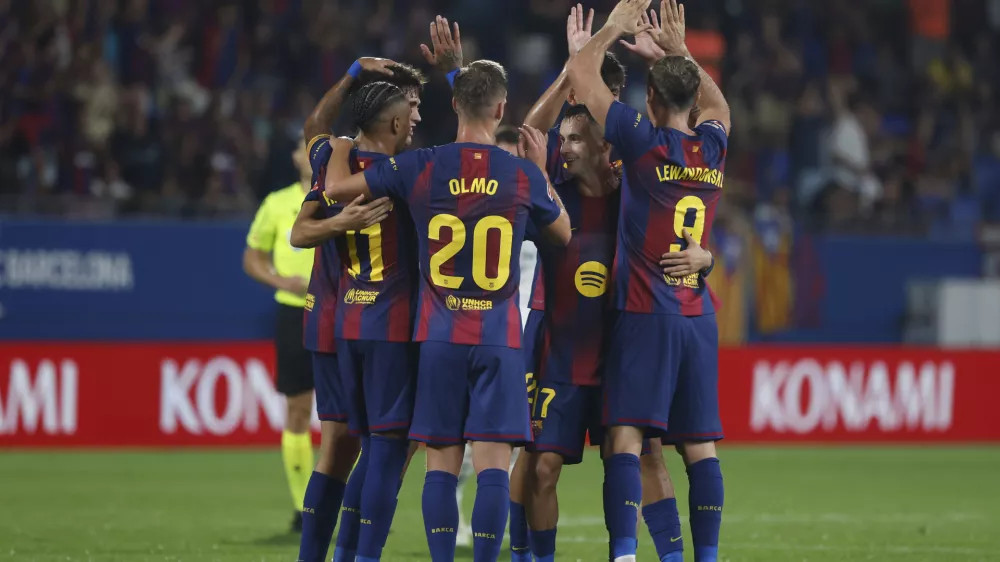 Barcelona's Robert Lewandowski, right, is congratulated after the VAR confirmed his side's 6th goal during a Spanish La Liga soccer match between FC Barcelona and Valencia at the Johan Cruyff stadium in Barcelona, Spain, Sunday, Sept. 14, 2025. (AP Photo/Joan Monfort)