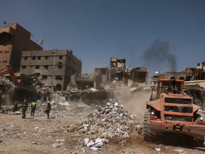 Members of civil defence stand as a bulldozer removes debris from the site of Wednesday's Israeli airstrikes, in Sanaa, Yemen September 14, 2025. REUTERS/Khaled Abdullah