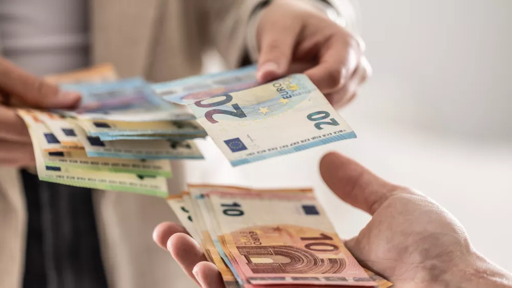 denar, plača, evro, evri, gotovina Businesswoman's hands exchanging euro banknotes, closeup shot.