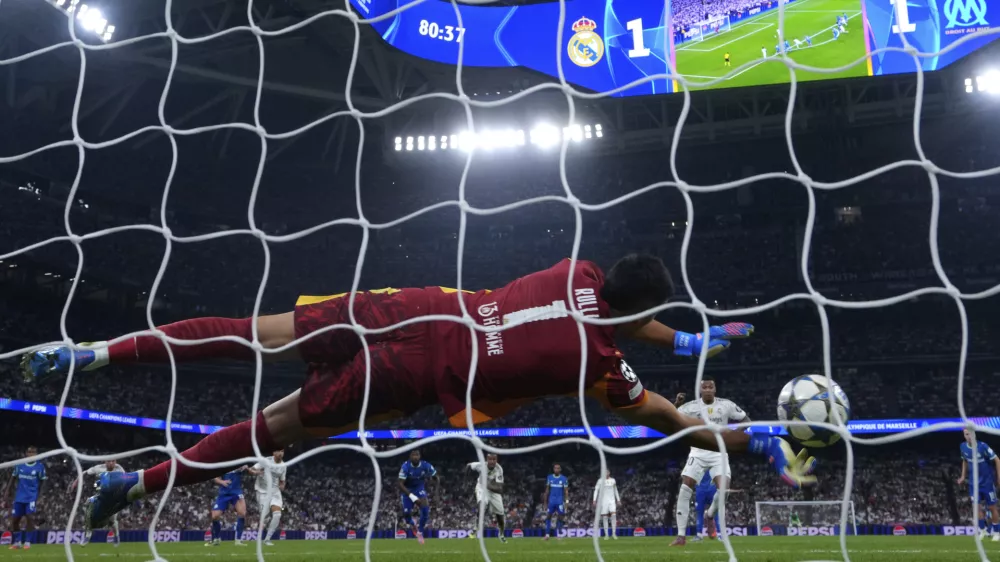 Real Madrid's Kylian Mbappe, right, shoots a penalty kick to score past Marseille's goalkeeper Geronimo Rulli his side's second goal during a Champions League opening phase soccer match between Real Madrid and Marseille at Santiago Bernabeu stadium, in Madrid, Tuesday, Sept. 16, 2025. (AP Photo/Manu Fernandez)