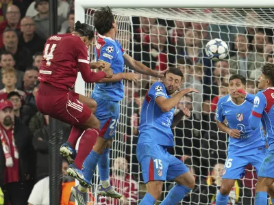 Liverpool's Virgil van Dijk, left, scores his side's third goal during the Champions League opening phase soccer match between Liverpool and Atletico Madrid at Anfield stadium in Liverpool, England, Wednesday, Sept. 17, 2025. (AP Photo/Jon Super)