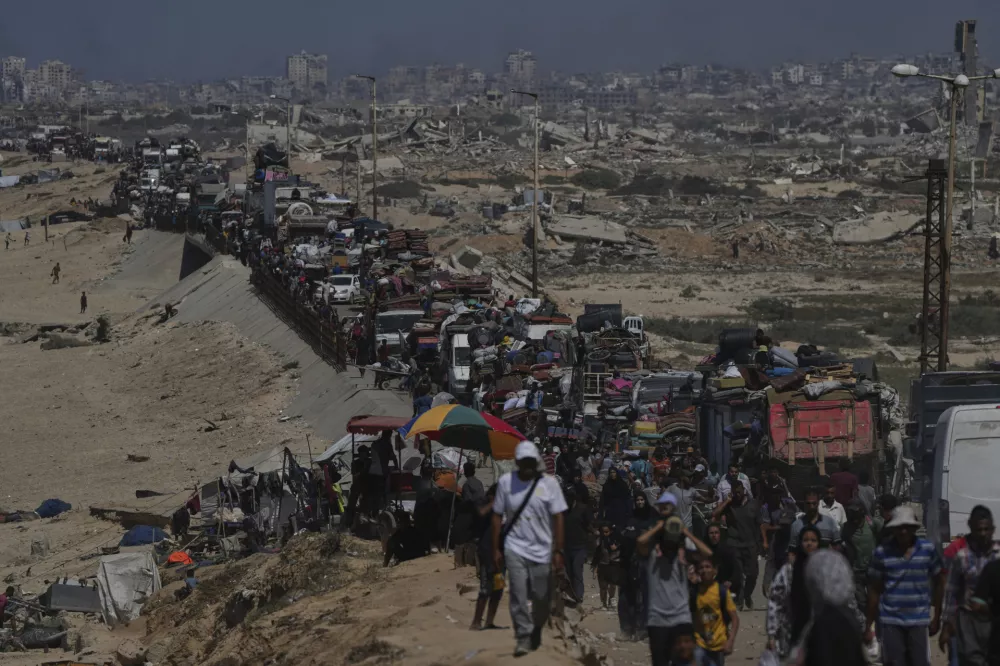 Displaced Palestinians flee Gaza City by foot and vehicles, carrying their belongings along the coastal road toward southern Gaza, Wednesday, Sept. 17, 2025. (AP Photo/Abdel Kareem Hana)