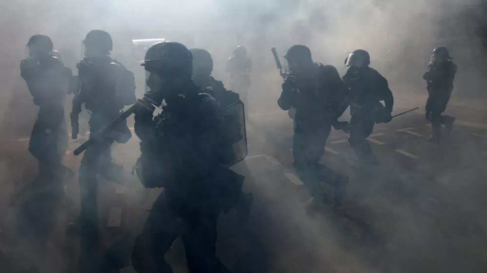 French gendarmes and riot police charge amid tear gas during clashes with protesters at a demonstration in Paris as part of a day of nationwide strikes and protests against the government and cuts in the next budget, with supporters of the "Bloquons Tout" (Let's Block Everything) movement, France, September 18, 2025. REUTERS/Tom Nicholson