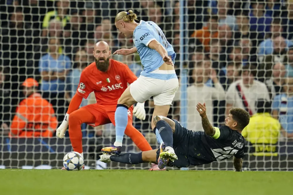 Napoli's Giovanni Di Lorenzo, right, fouls Manchester City's Erling Haaland to be shown a red card during the Champions League opening phase soccer match between Manchester City and Napoli at the Etihad Stadium in Manchester, England, Thursday, Sept. 18, 2025. (AP Photo/Dave Thompson)