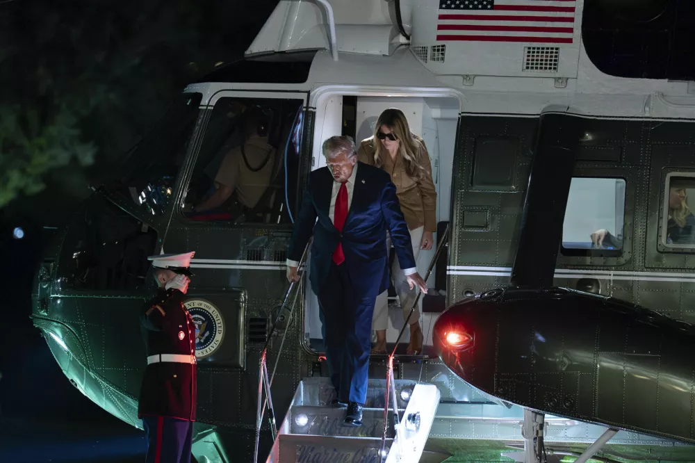 President Donald Trump and first lady Melania Trump step off Marine One upon arrival to the White House, in Washington, Thursday, Sept. 18, 2025. (AP Photo/Jose Luis Magana)
