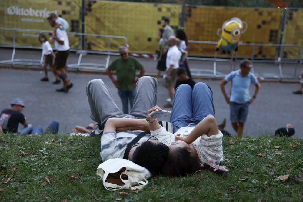 People lie on the ground on the day of the official opening of the 190th Oktoberfest, the world's largest beer festival in Munich, Germany, September 20, 2025. REUTERS/Maryam Majd