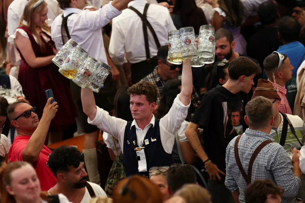 A man carries beer mugs on the day of the official opening of the 190th Oktoberfest, the world's largest beer festival in Munich, Germany, September 20, 2025. REUTERS/Maryam Majd