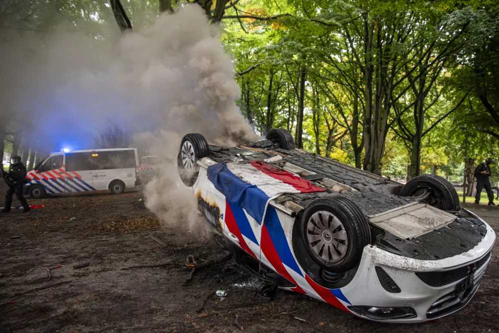 20 September 2025, Netherlands, The Hague: A police vehicle is set ablaze and flipped over during a far-right demonstration in The Hague, against immigration, asylum seekers, and violence in the country. Photo: James Petermeier/ZUMA Press Wire/dpa