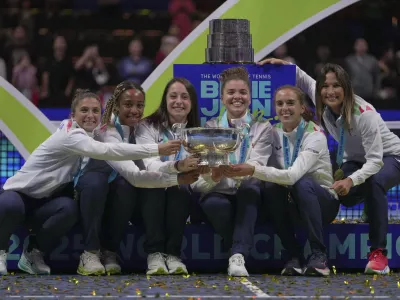 Italy's tennis team pose with the trophy on podium after winning the Billie Jean King Cup final against the United States, at the Shenzhen Bay Sports Center Arena, in Shenzhen, China's Guangdong province, Sunday, Sept. 21, 2025. (AP Photo/Andy Wong)