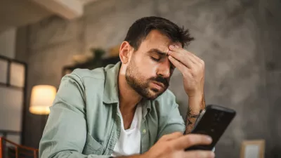 Portrait of adult furious man sit on chair and text sms on cellphone / Foto: Miljan Živković