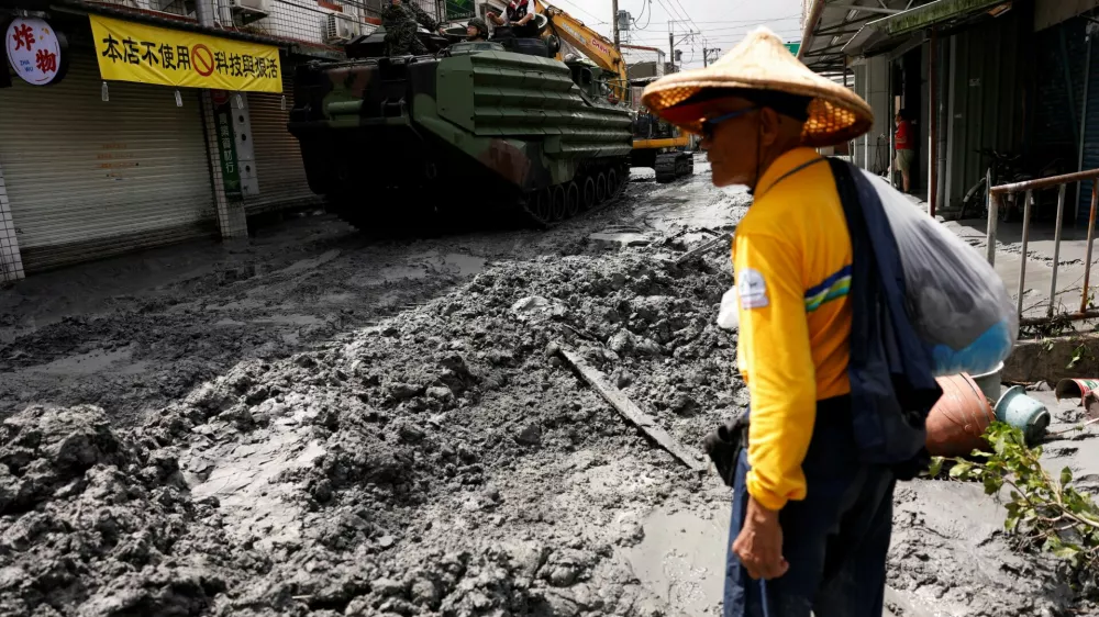 A man stands near a military vehicle on a road filled with mud brought by flooding, after Super Typhoon Ragasa in Hualien, Taiwan, September 24, 2025. REUTERS/Ann Wang   TPX IMAGES OF THE DAY