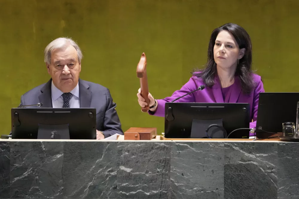 UN General Assembly President Annalena Baerbock gavels the meeting open as UN Secretary General Antonio Guterres listens during the 80th session of the United Nations General Assembly, Tuesday, Sept. 23, 2025. (AP Photo/Richard Drew)