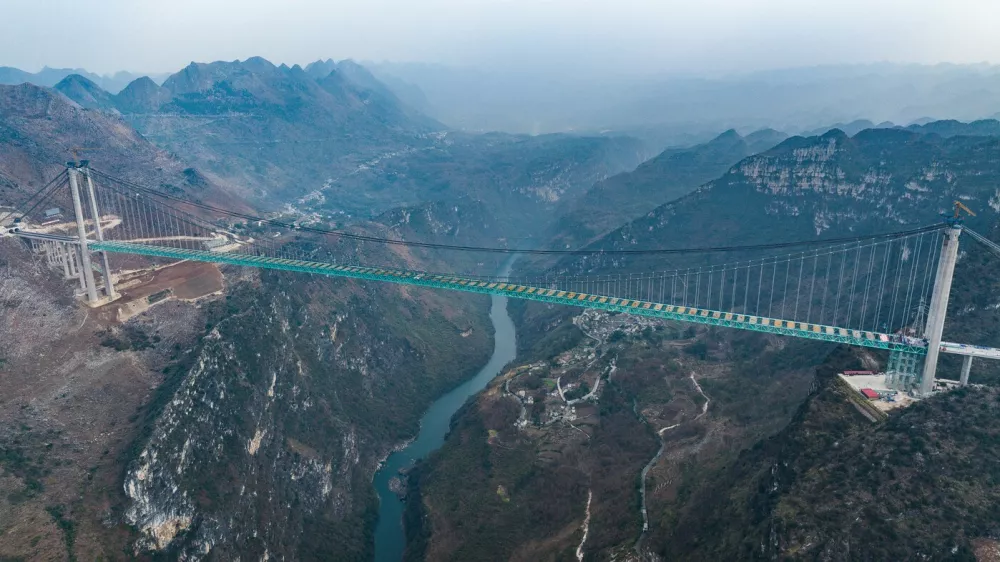 ZHENFENG, Jan. 17, 2025 -- An aerial drone photo taken on Jan. 17, 2025 shows a view of the Huajiang Grand Canyon Bridge in southwest China's Guizhou Province. China on Friday finished the construction of the main structure of the Huajiang Grand Canyon Bridge in its southwestern Guizhou Province, which is set to become the world's tallest bridge. A project of Guizhou Transportation Investment Group Co., Ltd., the suspension bridge has a vertical height of 625 meters from the bridge deck down to the river surface. The 2,890-meter bridge, with a span of 1,420 meters, is also the world's largest span bridge to be built in a mountainous area.,Image: 954481489, License: Rights-managed, Restrictions:, Model Release: noFoto: Profimedia / Foto: Foto: Profimedia