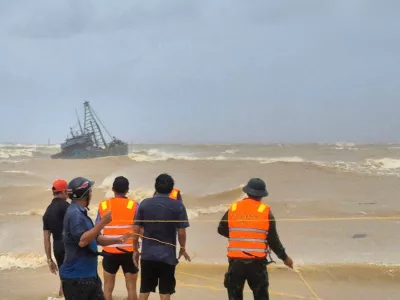 People work to rescue fishermen on a stranded fishing boat due to Typhoon Bualoi in Quang Tri, Vietnam Sunday, Sept. 28, 2025. (Trinh Quoc Dung/VNA via AP)
