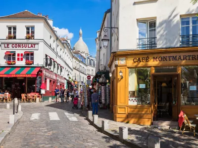 Paris, France - July 06, 2016: The charming quarter of Montmartre hill near basilica Sacre Coeur with traditional french cafes and art galleries. Montmartre is one of the most visited landmarks in Paris