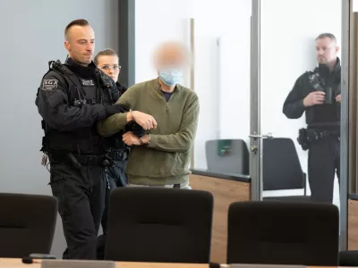 30 September 2025, Saxony, Dresden: The main defendant Jian G. (C) is escorted into the courtroom at the Dresden Higher Regional Court (OLG) prior to the announcement of the verdict in a high-profile espionage case. The proceedings concern a former employee of Alternative for Germany (AfD) parliamentarian Maximilian Krah and his alleged accomplice, accused of passing sensitive information to foreign actors. Photo: Sebastian Kahnert/dpa-pool/dpa - ACHTUNG: Der Angeklagte/ Verurteilte und andere prozessbeteiligte Person(en) wurde(n) aus rechtlichen Gr&uuml;nden gepixelt