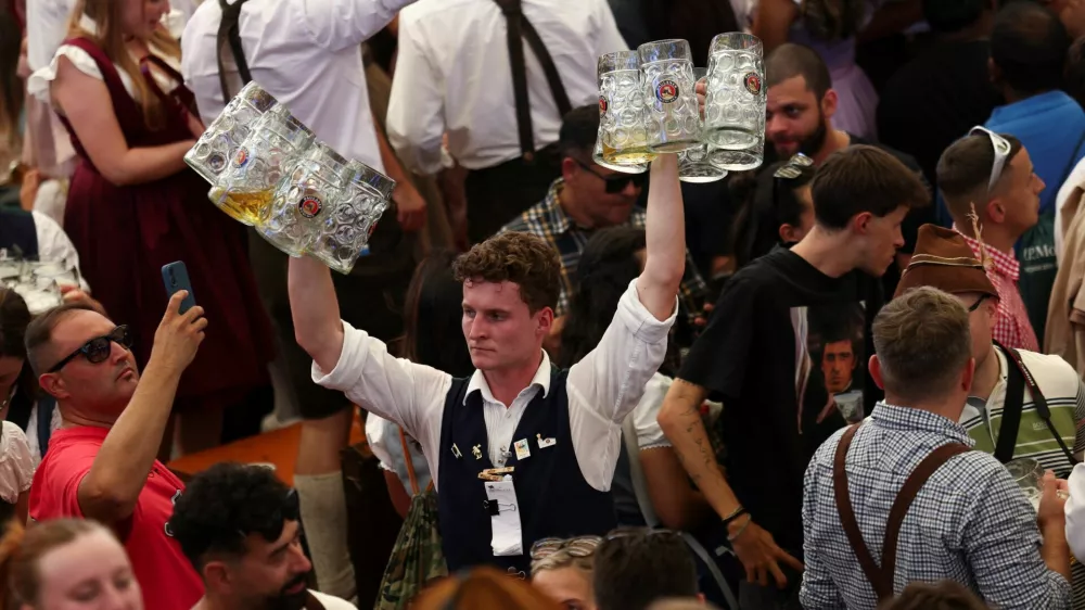 A man carries beer mugs on the day of the official opening of the 190th Oktoberfest, the world's largest beer festival in Munich, Germany, September 20, 2025. REUTERS/Maryam Majd