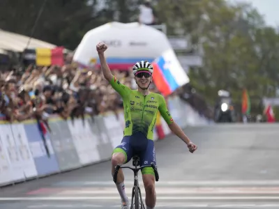 Slovenia's Tadej Pogacar celebrates winning the men's Elite road race, at the road cycling World Championships in Kigali, Rwanda, Sunday, Sept. 28, 2025. (AP Photo/Jerome Delay)