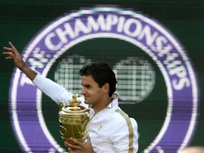FILE - Roger Federer of Switzerland holds the trophy after defeating Andy Roddick of U.S. in their men's final match on the Centre Court at Wimbledon, July 5, 2009. (AP Photo/Anja Niedringhaus, file)
