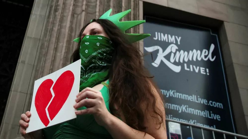 A woman wears a Statue of Liberty costume as she holds an image of a broken heart, outside the El Capitan Entertainment Centre, where "Jimmy Kimmel Live!" is recorded for broadcast, on Hollywood Boulevard in Los Angeles, California, U.S. September 17, 2025. REUTERS/Daniel Cole   TPX IMAGES OF THE DAY / Foto: Daniel Cole