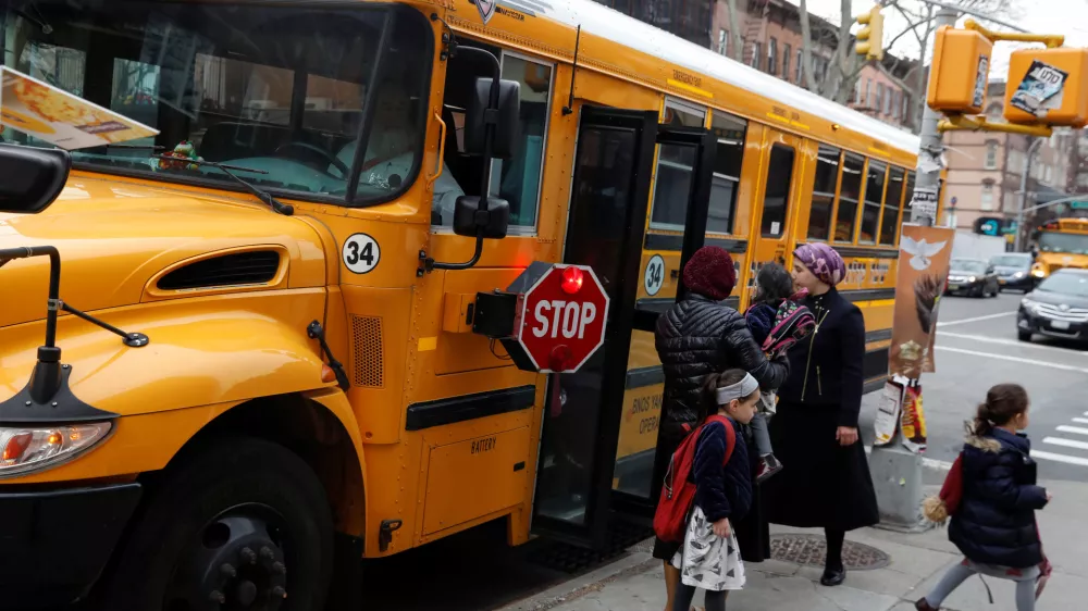 Orthodox Jewish children get off a Yeshiva school bus, as New York City Mayor Bill de Blasio declared a public health emergency in parts of Brooklyn in response to a measles outbreak, in the Williamsburg neighborhood of Brooklyn in New York City, U.S., April 9, 2019. REUTERS/Shannon Stapleton
